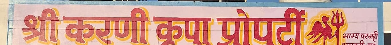 Close crop of the painted Karni Kripa Properties brand name on the Rohat signboard